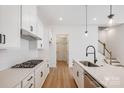 Modern kitchen with white cabinets, quartz countertops, and stainless steel appliances at 1198 Lost Cove Rd, Indian Land, SC 29707