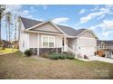 Beautiful home exterior featuring manicured lawn, stone accents, and attached garage at 159 Rubys Way # 35, Oakboro, NC 28129