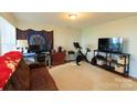 Den with a couch, TV, and exercise bike at 140 Rock Ridge Ln, Mount Holly, NC 28120