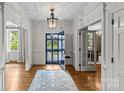 Bright foyer featuring hardwood floors, transom windows, chandelier, and doorway views at 1579 Queens W Rd, Charlotte, NC 28207