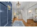 Inviting foyer with hardwood floors, staircase, chandelier, and bright, neutral decor at 1579 Queens W Rd, Charlotte, NC 28207