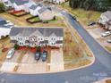 An aerial view of a neighborhood featuring well-maintained homes, green trees, and paved roads at 1708 Holliford Ct, Charlotte, NC 28215