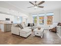 Open living space with L-shaped sofa, wood floors, and views of the backyard at 829 River Park Rd, Belmont, NC 28012