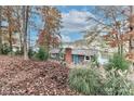 Gray lakefront house nestled among autumn trees at 110 Fern Haven Ln, Mooresville, NC 28117