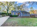 Charming blue home featuring a well-maintained lawn and mature trees at 13446 Idlefield Ln, Matthews, NC 28105