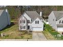 An eye-level view of a charming two-story home with mature landscaping, a driveway, and a two car garage at 3015 Hendricks Chapel Ln, Charlotte, NC 28216