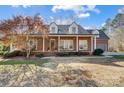 Charming brick home with a metal roof, dormer windows, and a welcoming front porch at 6610 Rolling Ridge Dr, Waxhaw, NC 28173