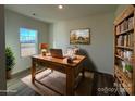 Bright home office features rustic wooden desk, built-in shelving, and large window at 168 Salem Springs Ln, Statesville, NC 28625