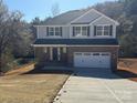 New two-story home with a brick facade, gray siding and two-car garage at 202 Fostoria Pl # 78B, Albemarle, NC 28001