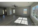 Bright, open-concept living room featuring vinyl floors, large windows, and modern ceiling fan at 202 Fostoria Pl # 78B, Albemarle, NC 28001