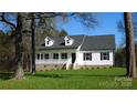 Charming white home with black shutters, dormers, and welcoming front porch framed by mature trees at 2270 Charlotte Hwy, York, SC 29745