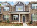 Charming brick townhome featuring gray shutters, craftsman columns, and professionally landscaped yard at 5527 Stafford Rd # 34, Charlotte, NC 28215