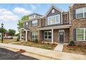 Charming brick townhome featuring gray shutters, craftsman columns, and professionally landscaped yard at 5527 Stafford Rd # 34, Charlotte, NC 28215
