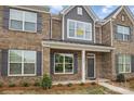 Charming brick townhome featuring gray shutters, craftsman columns, and professionally landscaped yard at 5527 Stafford Rd # 34, Charlotte, NC 28215