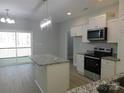 Well-lit kitchen with a center island, white cabinets, stainless steel appliances, and a sliding glass door to the deck at 1647 Davis Farm Rd, York, SC 29745
