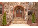 Stunning stone entryway with arched double doors and brick accents, creating a grand welcome at 1716 Funny Cide Dr, Waxhaw, NC 28173