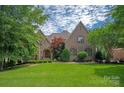 Charming brick home with a beautiful landscaped front yard and architectural details at 1716 Funny Cide Dr, Waxhaw, NC 28173