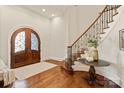 Grand foyer with hardwood floors, staircase, and arched entryways at 1716 Funny Cide Dr, Waxhaw, NC 28173