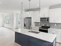 Modern kitchen featuring an island, stainless steel appliances, and white cabinetry at 6025 Countess Dr # 54, Charlotte, NC 28217