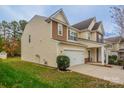 Side view of a two-story home featuring an attached two-car garage and manicured lawn at 7108 Kinley Commons Ln, Charlotte, NC 28278