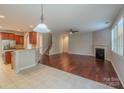 Open-concept living area with hardwood floors, fireplace, and seamless transition to the kitchen at 7108 Kinley Commons Ln, Charlotte, NC 28278