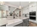 Bright kitchen features white cabinets, stainless steel appliances, and a large island with a farmhouse sink at 267 Triple Ponds Ct # 11, Clover, SC 29710