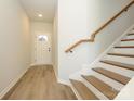 Bright entryway featuring wood-look flooring, a staircase with wooden treads, and a front door at 153 Halite Ln, Waxhaw, NC 28173