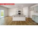 Modern kitchen with an island, granite countertops, and stainless steel appliances at 3861 Cullen Meadows Dr, Davidson, NC 28036