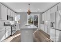 Bright kitchen with island, stainless steel appliances, and hardwood flooring at 582 West End Dr, Charlotte, NC 28208