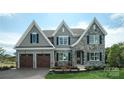 Charming two-story home boasting stone accents, grey siding, black shutters, and an attached two-car garage at Lot 42 Watercourse Way # Hawthorne, Belmont, NC 28012