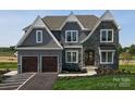Attractive two-story home featuring a stone facade, grey siding, and an attached two-car garage at Lot 42 Watercourse Way # Hawthorne, Belmont, NC 28012
