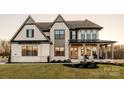 Elegant two-story home with a covered porch, complemented by stone and siding details at Lot 47 Watercourse Way # Devonshire, Belmont, NC 28012