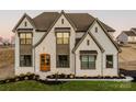 Beautiful exterior of stone and siding, featuring a prominent front door and manicured landscaping at Lot 47 Watercourse Way # Devonshire, Belmont, NC 28012