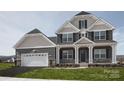 Two-story house with gray and brown siding, two-car garage, and front porch at Lot 51 Watercourse Way # Nottingham, Belmont, NC 28012