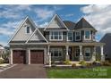 Two-story house with gray and stone siding, three-car garage, and front porch at Lot 51 Rivermist Dr # Nottingham, Belmont, NC 28012