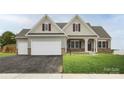 Beautiful home boasting a three-car garage, a cozy porch, and stone detailing at Lot 51 Watercourse Way # Arcadia, Belmont, NC 28012