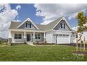 Inviting home featuring a covered porch, gray siding, and a three-car garage at Lot 51 Watercourse Way # Arcadia, Belmont, NC 28012