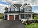 Attractive two-story house showcasing gray siding, black trim, a covered porch, and an attached three-car garage at Lot 51 Watercourse Way # Covington, Belmont, NC 28012