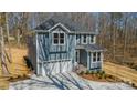 Two-story home with a two-car garage, gray siding, and white trim, surrounded by a wooded area at 149 Pinewood St, Troutman, NC 28166