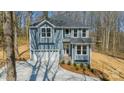 Two-story home with white garage door and gray siding, complemented by a green landscaped front yard at 149 Pinewood St, Troutman, NC 28166