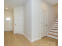 Bright entryway with hardwood floors, a white front door with glass and a staircase at 157 Halite Ln, Waxhaw, NC 28173