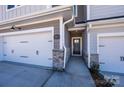Inviting townhome entrance with stone accents and a pathway to the front door and two-car garage at 157 Halite Ln, Waxhaw, NC 28173