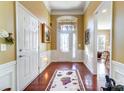 Inviting foyer with hardwood floors, decorative rug, high ceilings, and wainscoting at 2221 Hartwell Ln, Fort Mill, SC 29707