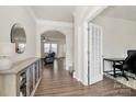 Inviting foyer with hardwood floors, elegant mirror, and an arched doorway leading to the living area at 913 Deep River Way, Waxhaw, NC 28173