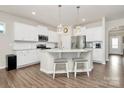 Beautiful kitchen with a large island, white cabinets, stainless steel appliances and hardwood floors at 913 Deep River Way, Waxhaw, NC 28173