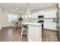 Bright open kitchen with white cabinets, stainless steel appliances, an island, and an adjacent dining area at 913 Deep River Way, Waxhaw, NC 28173