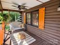 Cozy covered porch with a swing, ceiling fan, and rustic log siding at 13538 Pine Harbor Rd, Charlotte, NC 28278