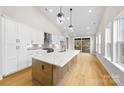 Modern kitchen with large island, white cabinets, and hardwood floors at 2205 Catalina Ave, Charlotte, NC 28206