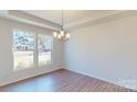 Bright dining room with modern chandelier, hardwood floors, and large windows with neighborhood view at 251 Winford Rd, Troutman, NC 28116