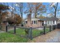 Cute brick home with a black fence and well-manicured lawn at 352 Leafmore Dr, Charlotte, NC 28213